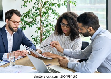 International executive business people team negotiating financial research report at boardroom meeting table. Multiracial team doing paperwork for developing business strategy plan in modern office. - Powered by Shutterstock