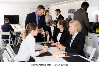  International Group Of Business People Chatting While Enjoying Coffee In Break Room