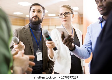 International Group Of Journalists Asking Questions At Press Conference Taking Interview And Handing Recording Devices And Microphones