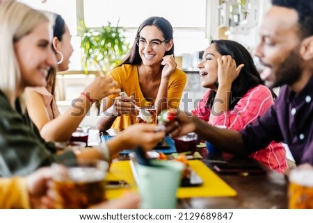 International group of young student friends having breakfast drinking and eating together in coffee shop - People, food and beverage concept