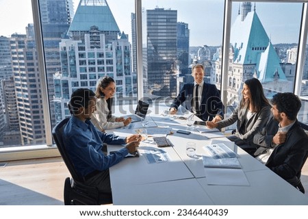 International happy professional business team consulting at group meeting. Multicultural busy coworkers working together in teamwork discussing project managing work plan in office board room.