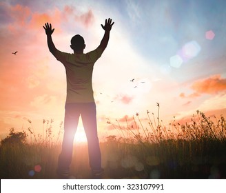 International Human Rights Day Concept: Silhouette Humble Man Raised Hands For Praise And Worship God Over Meadow Autumn Sunrise Background