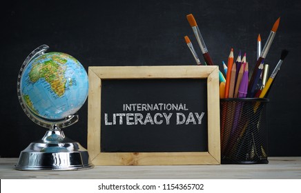 International Literacy Day. World Globe, School Stationary And Alarm Clock