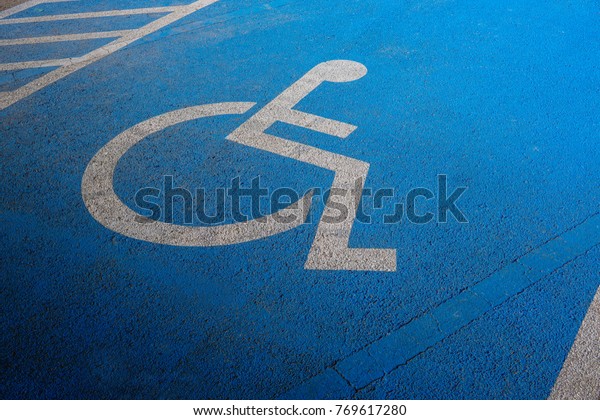 International markings for a\
handicapped parking, Disabled symbol sign on blue asphalt in\
parking space