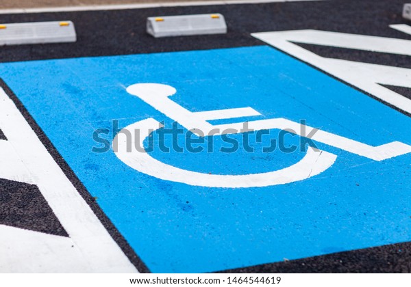 The international markings for a handicapped parking\
stall in a parking lot.