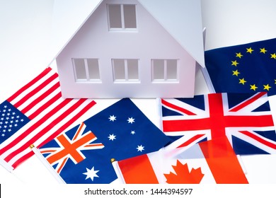 International Sale Of Real Estate. Timeshare Rental Homes In Different Countries. House On The Background Of The Flags Of The USA, England And Australia. Real Estate In Canada. Buying An Apartment 