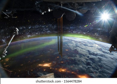 International space station on orbit of Earth planet. ISS. Stars and galaxies, city lights and aurora polaris, lens flare and clouds. Elements of this image furnished by NASA. - Powered by Shutterstock