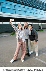 international students taking selfie portrait together outdoor. Group of high school teens with phones outside college. Multiethnic millenial friends spend free time together.  - Shutterstock ID 2207543225