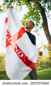 International Support. Portrait Of Young Handsome Man Holding Flag Of England Isolated Over Natural Landscape. Intercultural Communication. Concept Of World Friendship, Multinational Union, Ad