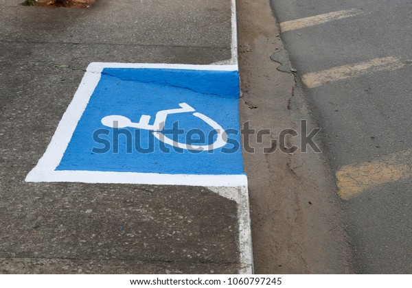 International symbol for wheelchair users\
designed on\
sidewalk