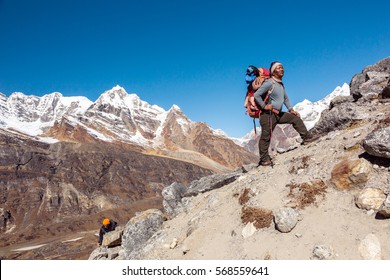 International Team Of Mountain Climbers Ascending Himalaya Summit Led By Iconic Nepalese Sherpa Guide Staying With Backpack And Alpine Gear And Planning Further Route