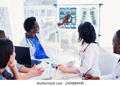 International team of young doctors discussing computed tomography result in the clinic. Showing patients results at modern progressive diagnostic centre. Medicine and healthcare concept. - Powered by Shutterstock