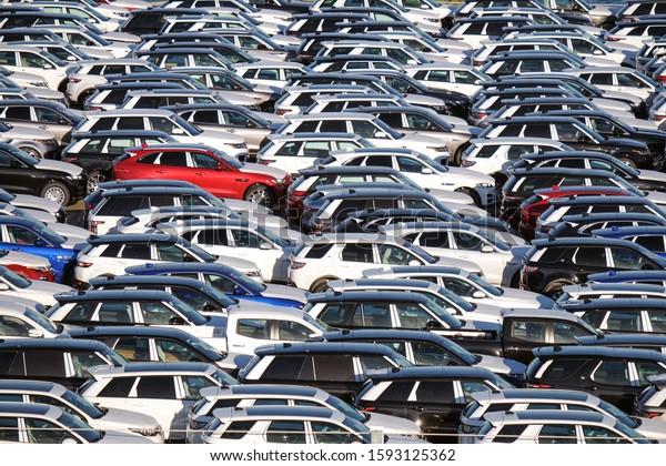 International trade concept: Numerous brand\
new cars are waiting to be\
transported