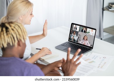 International Video Call. Group Chat. Digital Conference. Diverse Business Team Meeting Online Greeting Waving Hello On Laptop Screen In Virtual Office.