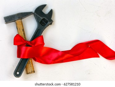 International Worker Solidarity Day, 1 May concept, hammer and wrench with red tape on a white textured surface - Powered by Shutterstock