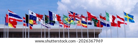  Internationnal flags flying in the wind clourd and blue sky background.