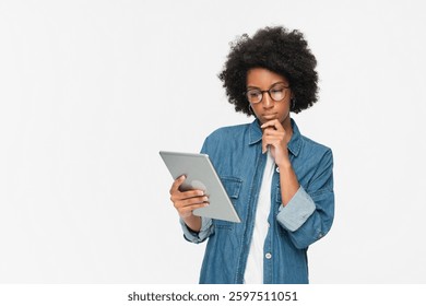 Internet browsing. Digital network. Gadget technology. Pensive thinking African woman using holding PC digital tablet pad standing isolated on white background.