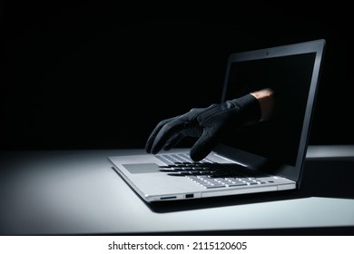 internet fraud and cyber attack concept. thief hand out of laptop screen