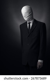 Internet meme and terrible character Halloween theme: very tall burly man with long arms in a suit with bandaged face fabric, an unknown killer in the suit, The Slender Man, Secret legend of the city