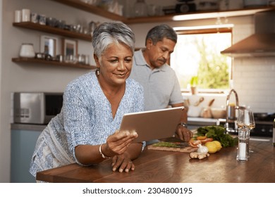 Internet, old woman at kitchen counter with man and tablet, cooking healthy food together in home. Digital recipe, health and senior couple with meal prep, happiness and wellness diet in retirement. - Powered by Shutterstock