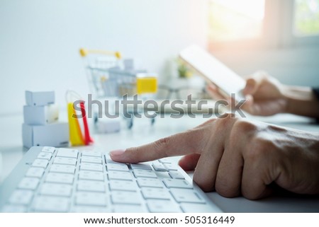 Internet online shopping concept with laptop and shopping-cart.Vintage tone retro filter effect,soft focus(selective focus)

