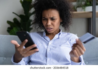 Internet Scam Victim. Stressed Young Black Woman Having Problems With Paying Online By Credit Card Via Cellphone. Frustrated Mixed Race Lady Deal With Fraudulent E Money Operation Overspending Or Debt