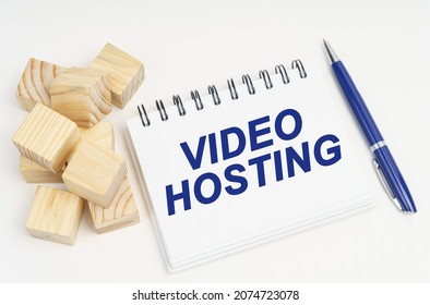Internet and security concept. On the table are cubes, a pen and a notebook with the inscription - Video Hosting