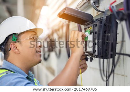 An internet technician is repairing or maintaining a fiber optic connection by opening a fiber optic connector.