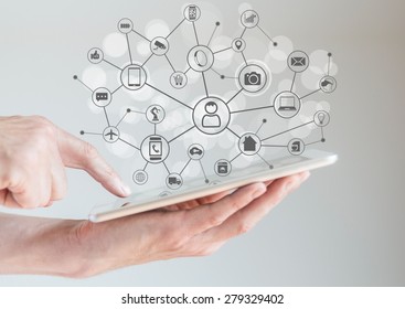 Internet of Things concept (IoT) with male hands holding tablet or large smart phone in order to connect various devices and smart machines. - Shutterstock ID 279329402