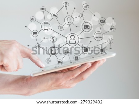 Internet of Things concept (IoT) with male hands holding tablet or large smart phone in order to connect various devices and smart machines.