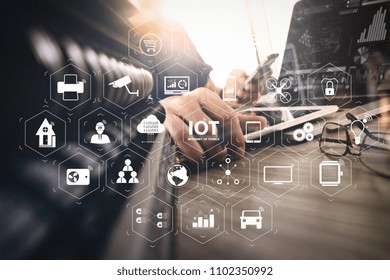 Internet of Things (IOT) technology with AR (Augmented Reality) on VR dashboard. designer hand working with digital tablet and laptop computer and book stack and eye glass on wooden desk as concept
