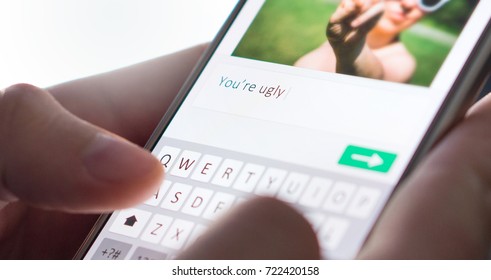 Internet troll sending mean comment to picture on an imaginary social media website with smartphone. Cyber bullying and bad behavior online concept.