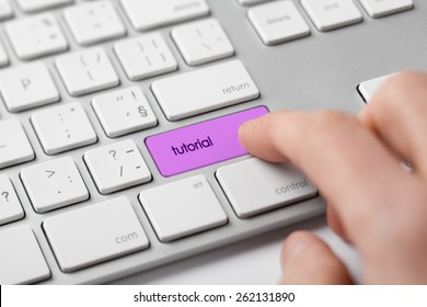 Internet tutorial concept. Man click on keypad with text tutorial. 