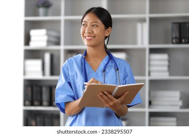 Internship medical students carry bags and textbooks in the library. - Powered by Shutterstock