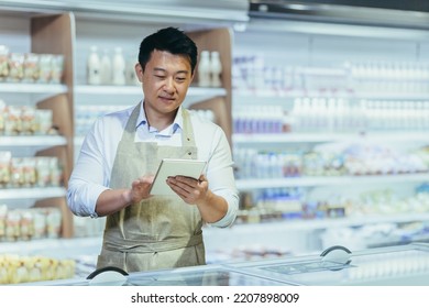 Internship At Work. A Young Man, An Asian Stager,student, An Assistant Works In A Supermarket