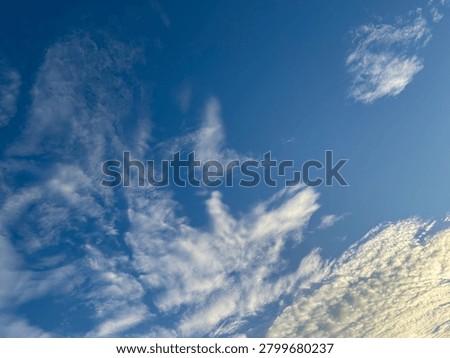 interplay of ethereal wisps and dense cloud structures traversing a vast cerulean vault