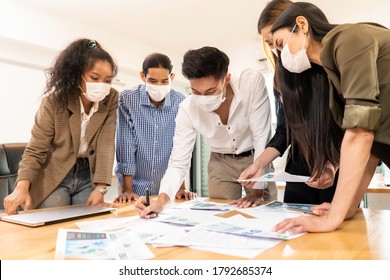 Interracial asian business team brainstorming idea at office meeting room after reopen due to coronavirus COVID-19 city lockdown. They wear face mask reduce risk to infection as new normal lifestyle. - Powered by Shutterstock