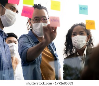 Interracial asian business team brainstorming idea at office meeting room after reopen due to coronavirus COVID-19 city lockdown. They wear face mask reduce risk to infection as new normal lifestyle. - Powered by Shutterstock