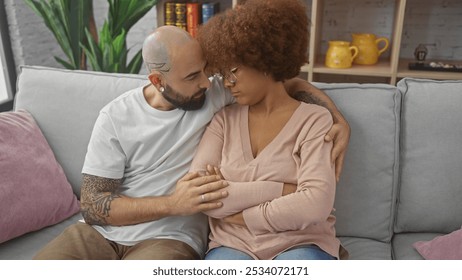 Interracial couple embracing affectionately on a cozy home sofa, depicting love and comfort in an indoor setting. - Powered by Shutterstock