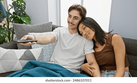 Interracial couple enjoying time together watching tv in a cozy living room setting. - Powered by Shutterstock