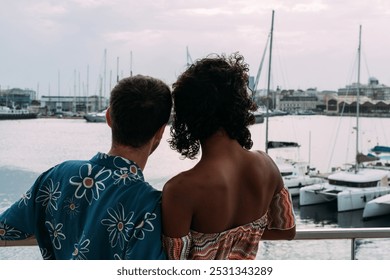 Interracial couple enjoys a peaceful moment on a charming balcony overlooking a lively marina with boats, feeling love and togetherness on a romantic getaway - Powered by Shutterstock