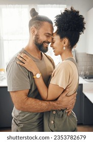 Interracial couple, hug and forehead touch in kitchen, love and bonding with happiness while at home. Trust, support and commitment, affection and embrace with people in a healthy relationship