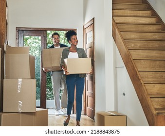 Interracial couple moving into a new modern house, carrying boxes and arriving home together. Happy, excited and smiling husband and wife walking, entering and relocating after buying an apartment - Powered by Shutterstock