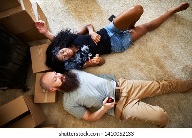 Interracial Couple Relaxing After Hard Work Moving By Smoking Marijuana Joint Together While Laying On Floor