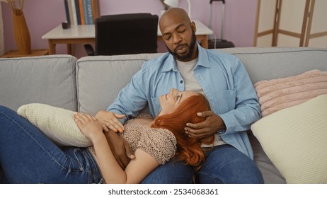 Interracial couple relaxing on a cozy sofa in a living room, capturing a heartfelt moment of love and togetherness, man gently holding womanâ€™s head as she smiles up lovingly. - Powered by Shutterstock