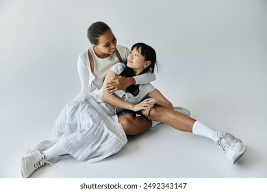 An interracial couple shares a tender moment, embracing each other on a simple backdrop. - Powered by Shutterstock