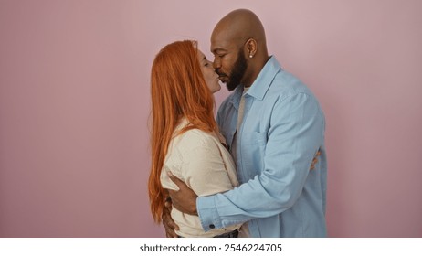 Interracial couple sharing a kiss against an isolated pink background, capturing love and togetherness in a tender moment featuring a man and woman. - Powered by Shutterstock