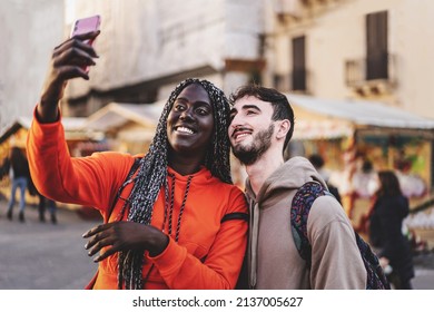 interracial couple of young people taking a selfie to the city market - tourists shooting moments together - Powered by Shutterstock