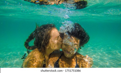 Interracial Female Couple kiss underwater - Powered by Shutterstock