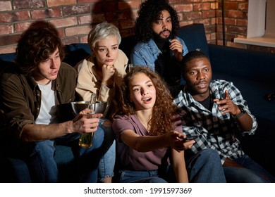 Interracial Group Of Friends Discuss Which Movie To Watch, Sitting On Sofa At Home, Choosing The Most Interesting Film, Relaxed Guys And Ladies Have Talk, Switch Channels On TV